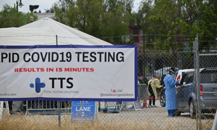 Trabajadores sanitarios recogen información de las personas que llegan para someterse a las pruebas de COVID-19, en un centro de análisis en Los Ángeles, California, el 18 de julio de 2021. (Robyn Beck/AFP vía Getty Images)
