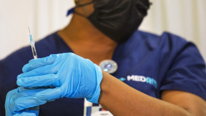 Un empleado médico prepara una dosis de la vacuna contra COVID-19 en un sitio de vacunación emergente en el Lower East Side en la ciudad de Nueva York, el 8 de noviembre de 2021. (Michael M. Santiago/Getty Images)