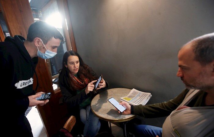 Una pareja muestra su certificado de vacunación al responsable de un bar del barrio de Gracia de Barcelona, este viernes, cuando los contagios de coronavirus siguen creciendo en Cataluña, y ha entrado en vigor la obligatoriedad, avalada por el TSJC, del pasaporte COVID-19 para entrar en bares, restaurantes, gimnasios y residencias, en un intento de aumentar una vacunación que está estancada y frenar el aumento de infecciones que están incrementando los ingresos hospitalarios. EFE/Marta Pérez