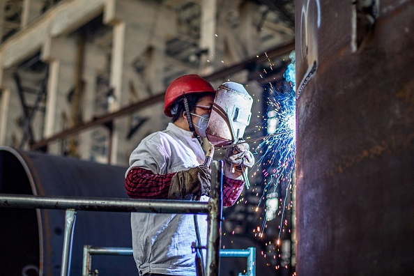 Un trabajador produce una máquina de fabricación en una fábrica de Nantong, en la provincia oriental china de Jiangsu, el 26 de mayo de 2021. (STR/AFP vía Getty Images)