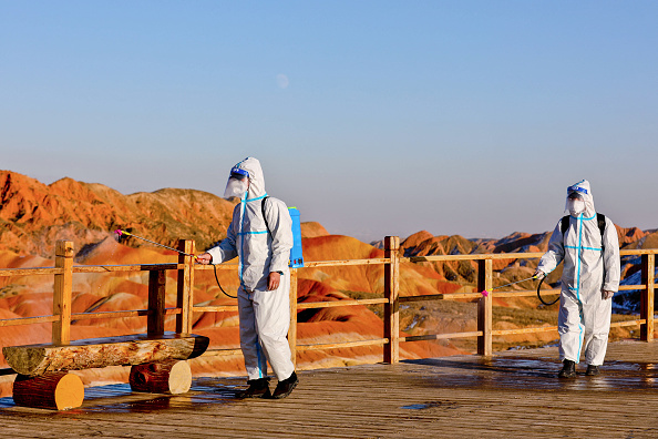 Miembros del personal rociando desinfectante, el 15 de noviembre de 2021, en el Zhangye Danxia Geopark en Zhangye en la provincia de Gansu, mientras el parque se prepara para reabrir después de cerrar debido al brote de COVID-19 . (STR/AFP vía Getty Images)