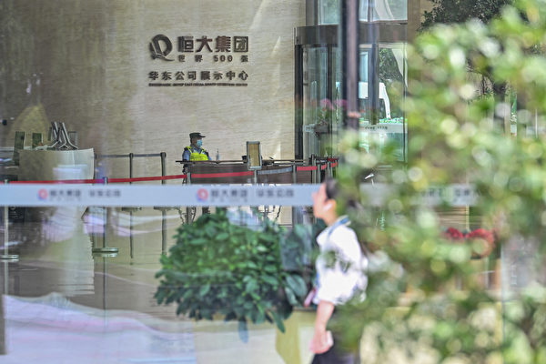 Un agente de policía es visto en el vestíbulo del edificio Evergrande Center en Shanghái el 24 de septiembre de 2021. (Hector Retamal/AFP vía Getty Images)