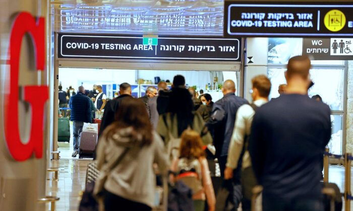 Varios pasajeros caminan con su equipaje a su llegada al aeropuerto Ben Gurion cerca de Lod (Israel) el 1 de noviembre de 2021. (Jack Guez/AFP vía Getty Images)