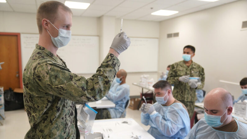 El personal de la Marina prepara dosis de una vacuna contra el COVID-19 en un sitio de vacunación en la ciudad de Nueva York el 24 de febrero de 2021. (Seth Wenig / Pool / AFP a través de Getty Images)