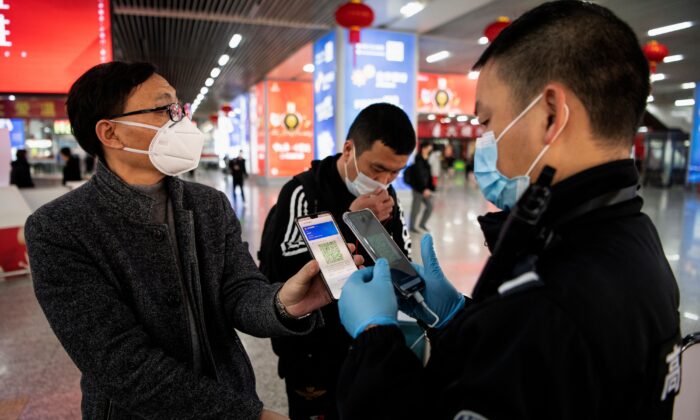 Un pasajero muestra un código QR verde en su teléfono para mostrar su estado de salud a la seguridad, al llegar a la estación de tren de Wenzhou, en Wenzhou, China, el 28 de febrero de 2020. (Noel Celis/AFP vía Getty Images)
