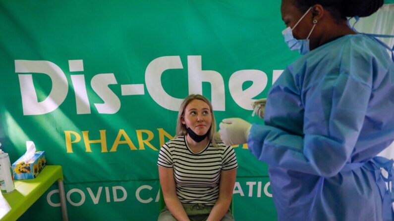 Una trabajadora de la salud se prepara para realizar una prueba de COVID-19 en un viajero en el Aeropuerto Internacional OR Tambo en Johannesburgo, Sudáfrica, el 27 de noviembre de 2021. (Phill Magakoe/AFP a través de Getty Images)