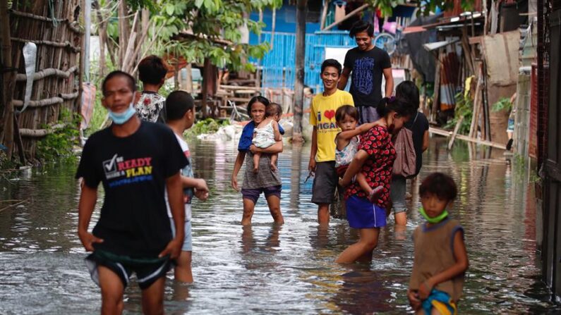 Los aldeanos vadean las aguas de la inundación traídas por el tifón Conson en la ciudad de Muntinlupa, Metro Manila, Filipinas, el 10 de septiembre de 2021, en una foto de archivo. EFE/EPA/Francis R. Malasig