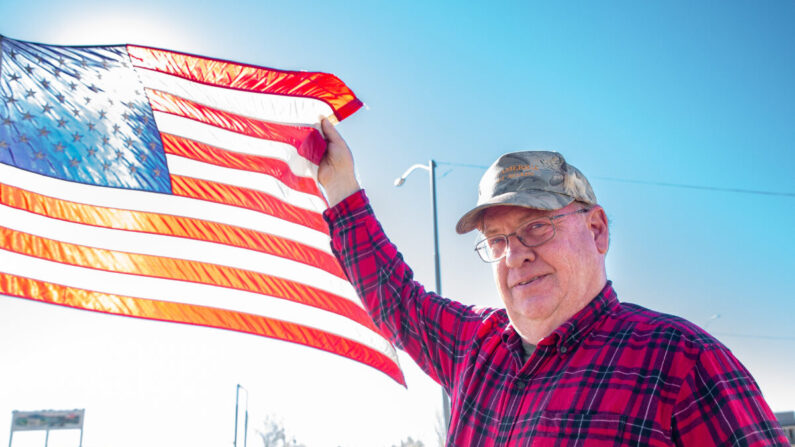 El residente Richard Frei sostiene una bandera estadounidense en Winslow, Arizona, el 4 de diciembre de 2021. (John Fredricks/The Epoch Times)