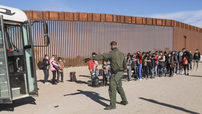 Un agente de la Patrulla Fronteriza organiza a los inmigrantes ilegales que se han reunido junto a la valla fronteriza tras cruzar de México a Estados Unidos en Yuma, Arizona, el 10 de diciembre de 2021. (Charlotte Cuthbertson/The Epoch Times)