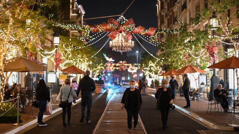 Los compradores llevan mascarillas protectoras en un centro comercial y complejo residencial al aire libre en Glendale, California, el 1 de diciembre de 2021. (ROBYN BECK/AFP vía Getty Images)