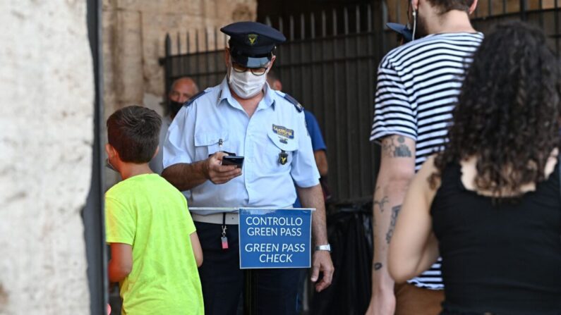 Los visitantes muestran sus certificados COVID-19 escaneados antes de entrar en el Antiguo Coliseo en el centro de Roma el 6 de agosto de 2021. (Andreas Solaro/AFP vía Getty Images)