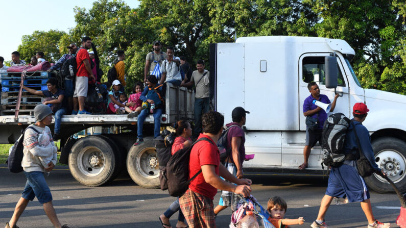 Migrantes que se dirigen en caravana hacia Estados Unidos, viajan en la parte trasera de un camión hacia la Ciudad de México para solicitar asilo y estatus de refugiado en Mapastepec, Estado de Chiapas, México, el 1 de noviembre de 2021. (Isaac Guzman/AFP vía Getty Images)