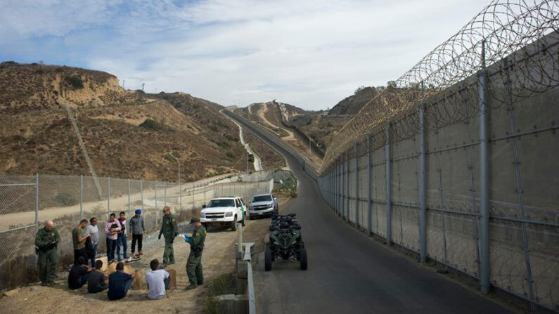 Fotografía de archivo de un grupo de hombres ilegales que intentaban cruzar la frontera y fueron detenidos por agentes de Patrulla Fronteriza, en San Diego, California (Estados Unidos). EFE/David Maung