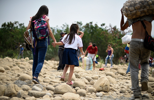 La venezolana Leidy Navarro (Izq.) camina con su hija Valentina Cáceres de regreso a su casa en Ureña, Venezuela, después de recogerla en la escuela en Cúcuta, Colombia, el 6 de marzo de 2019.  (El crédito de la foto debe decir JUAN PABLO BAYONA/AFP a través de Getty Images)