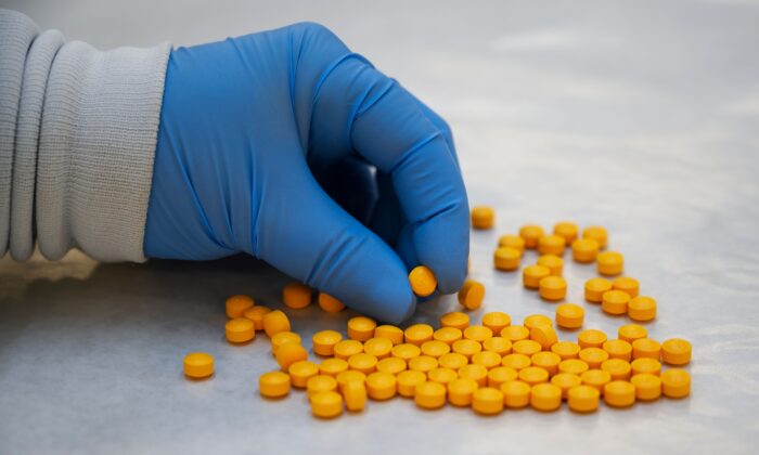 Un químico de la Administración para el Control de Drogas (DEA) revisa las píldoras confiscadas que contienen fentanilo en el Laboratorio Regional del Noreste de la DEA en Nueva York el 8 de octubre de 2019. (Don Emmert/AFP vía Getty Images)
