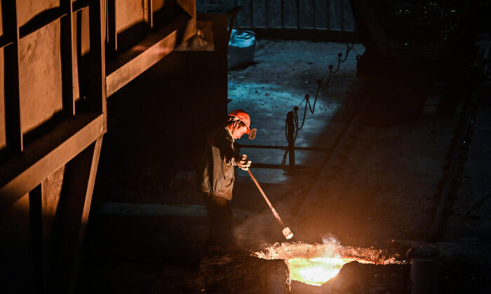 Un trabajador extrae una muestra de metal fundido durante una gira organizada por el gobierno en una planta de la empresa de fundición y herramientas de alta calidad, Tiangong International, en la provincia de Jiangsu, en el este de China, el 12 de octubre de 2020. (Hector Retamal/AFP a través de Getty Images)
