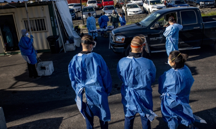 Los trabajadores de la salud administran pruebas de COVID-19 gratuitas a las personas en sus automóviles en el estacionamiento del Centro de Bienestar y Salud Familiar Columbus West en Columbus, Ohio, el 19 de noviembre de 2020. (Stephen Zenner/AFP a través de Getty Images)