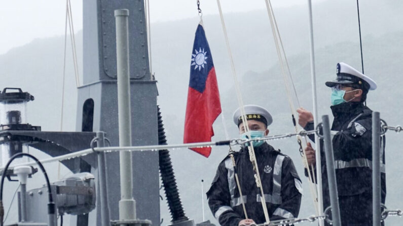 Dos soldados de la marina izan la bandera nacional de Taiwán durante una ceremonia oficial en un astillero en Su'ao, un municipio del condado de Yilan, al este de Taiwán, el 15 de diciembre de 2020. (Sam Yeh/AFP vía Getty Images)
