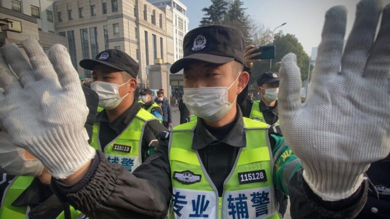 La policía intenta impedir que los periodistas graben imágenes en el exterior del Tribunal Popular del Nuevo Distrito de Shanghai, donde el periodista ciudadano chino Zhang Zhan será juzgado en Shanghai el 28 de diciembre de 2020. (Leo Ramirez/AFP vía Getty Images)