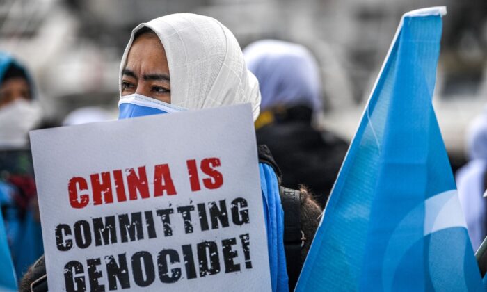 Miembros de la minoría de Mujeres Musulmanas Uigur sostienen carteles y banderas del este de Turkestán mientras se manifiestan para pedir noticias de sus familiares y expresar su preocupación por la ratificación de un tratado de extradición entre China y Turquía, cerca del consulado de China en Estambul, el 8 de marzo de 2021, durante un Día Internacional de la Mujer. (Ozan Kose/AFP a través de Getty Images)