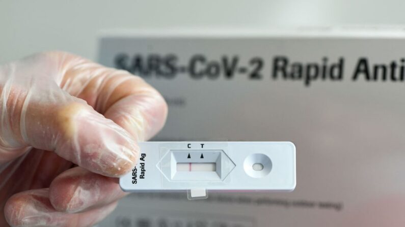 Un médico muestra una prueba rápida de antígeno negativa en el centro de pruebas Corona, en una sala especialmente creada para ello junto a la farmacia "Loewen" de Hagen, en el oeste de Alemania, el 10 de marzo de 2021. (Ina Fassbender/AFP vía Getty Images)
