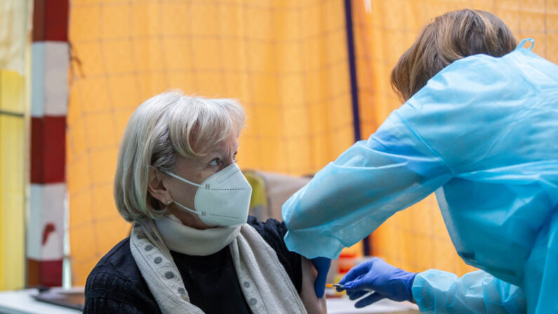 Una mujer recibe una dosis de la vacuna contra el COVID-19 de Pfizer-BioNTech en el centro de vacunación de un pabellón deportivo el 18 de marzo de 2021 en Klanovice, República Checa. (Gabriel Kuchta/Getty Images)