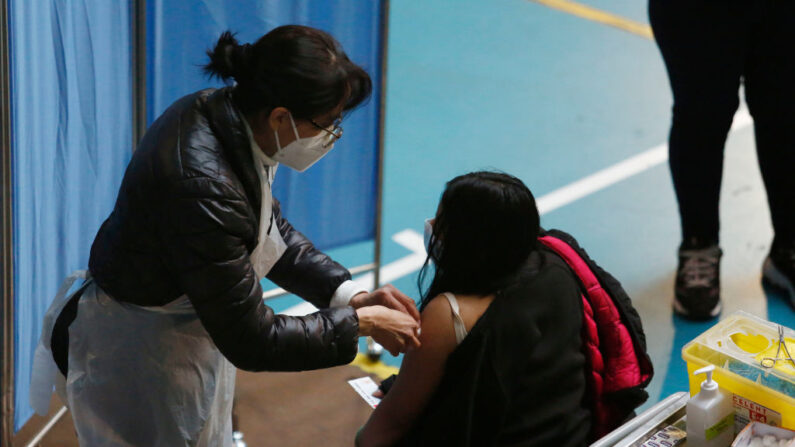 Una trabajadora sanitaria vacuna a una ciudadana con Astrazeneca como tercera dosis de refuerzo contra el covid-19 el 10 de agosto de 2021 en La Florida, Chile. (Marcelo Hernández/Getty Images)
