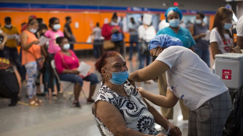 Una mujer es inoculada contra el COVID-19 en el Metro de Santo Domingo (República Dominicana), el 18 de octubre de 2021. (Erika Sanlices/AFP vía Getty Images)