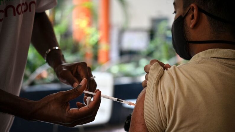 Un estudiante mayor de 12 años está siendo inoculado con vacuna contra la COVID-19 en el centro educativo Andrés Bello de Caracas (Venezuela), el 9 de noviembre de 2021. (Yuri Cortez/AFP vía Getty Images)