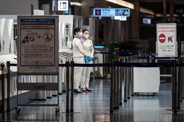 Personal permanece en la puerta de salida del aeropuerto internacional de Haneda de Tokio el 29 de noviembre de 2021, cuando Japón anunció sus planes de prohibir a todos los nuevos viajeros extranjeros debido a la variante ómicron de COVID-19. (Foto de PHILIP FONG/AFP a través de Getty Images)