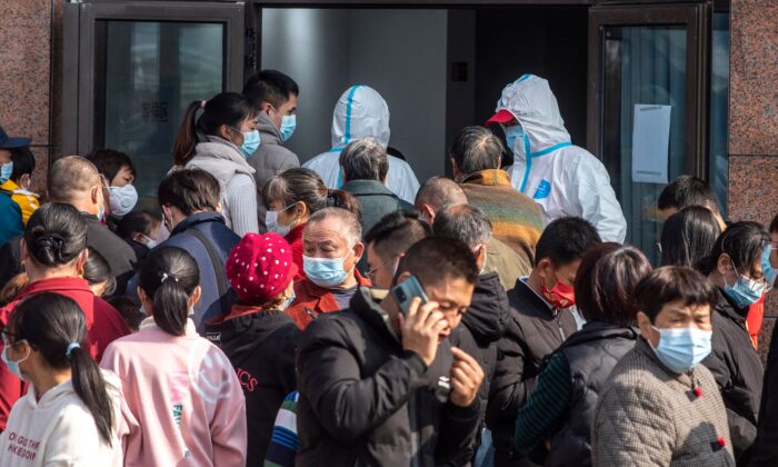 Las personas esperan para someterse a las pruebas de ácido nucleico del coronavirus Covid-19 durante un análisis masivo en Ningbo, en la provincia oriental china de Zhejiang, el 7 de diciembre de 2021. (STR/AFP vía Getty Images)