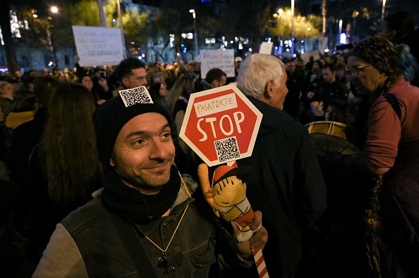 Un manifestante con un muñeco de "Cobi", la mascota oficial de los Juegos Olímpicos de Verano de 1992, participa en una manifestación contra el pasaporte sanitario obligatorio COVID-19, con el que las autoridades pretenden limitar la propagación de la pandemia de Covid-19, en Barcelona, el 11 de diciembre de 2021. (LLUIS GENE/AFP vía Getty Images)