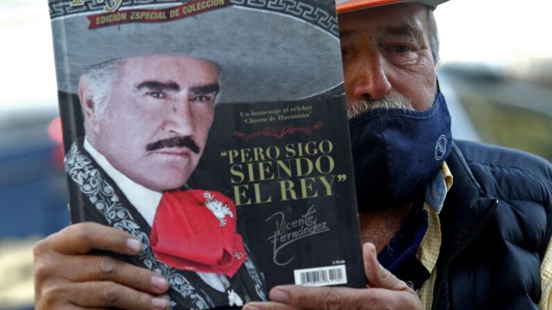 Miguel del Toro muestra un libro sobre el cantante mexicano Vicente Fernandez, fuera del hospital donde falleció el cantante en Guadalajara, Mexico, 12 de diciembre de 2021. (ULISES RUIZ/AFP via Getty Images)