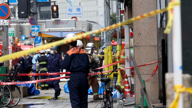 Los bomberos trabajan frente a un edificio, donde se produjo un incendio en Osaka (Japón) el 17 de diciembre de 2021. (STR/JIJI PRESS/AFP vía Getty Images)