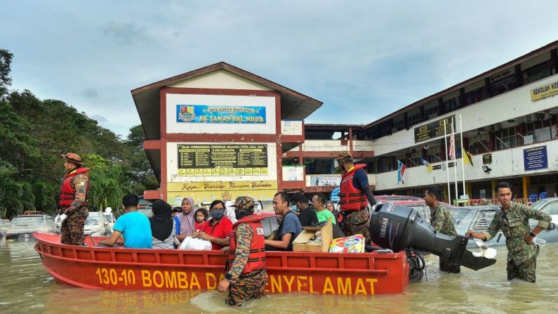 Funcionarios de rescate evacuan a personas en un barco en Shah Alam, Selangor, el 20 de diciembre de 2021, mientras Malasia se enfrenta a algunas de sus peores inundaciones en años. (Arif Kartono/AFP vía Getty Images)