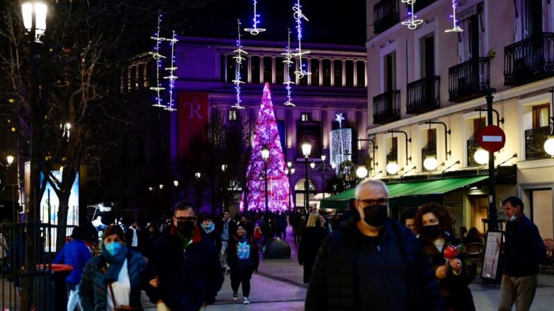 Transeúntes caminan junto a las luces de Navidad en las calles de Madrid (España), el 22 de diciembre de 2021. (Javier Soriano/AFP vía Getty Images)
