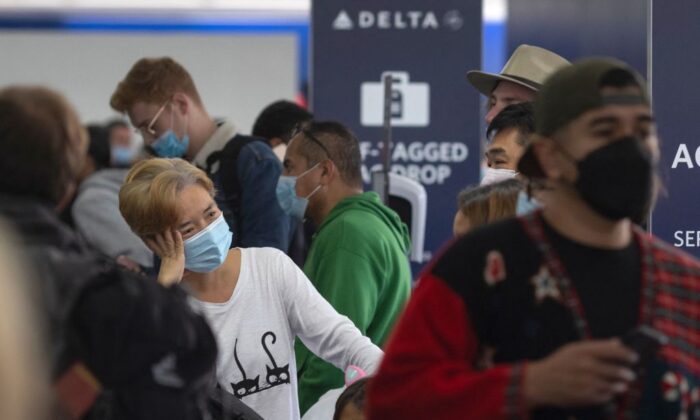 Viajeros esperan en la fila de facturación de Delta Airlines en el Aeropuerto Internacional de Los Ángeles en Los Ángeles, California, el 24 de diciembre de 2021. (David McNew/AFP vía Getty Images)