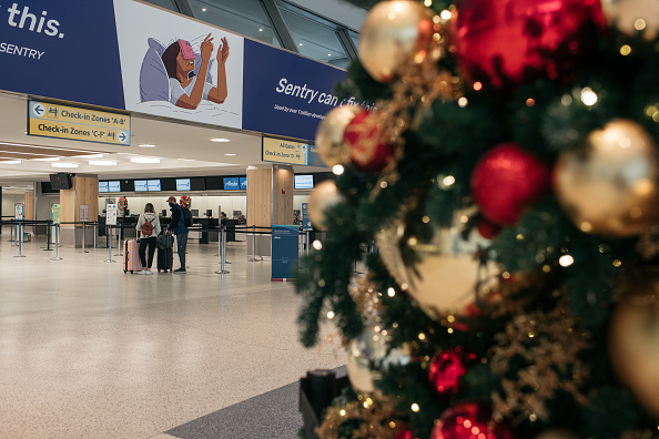 Los viajeros caminan por la sala de salidas de la Terminal 7 del Aeropuerto Internacional John F. Kennedy, el 24 de diciembre de 2021, en la ciudad de Nueva York. Miles de viajeros se quedaron varados en todo el país luego de que varias aerolíneas cancelaran sus vuelos de Nochebuena el viernes debido al aumento de los casos de la variante ómicron de COVID-19, la escasez de personal y el mal tiempo. (Foto de Scott Heins/Getty Images)