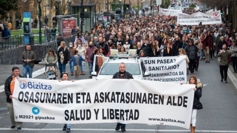 Manifestantes participan en una marcha convocada por la asociación "Bizitza" (Vida), para protestar contra el pase sanitario y las vacunas Covid-19 para niños, en la ciudad vasca española de San Sebastián, el 26 de diciembre de 2021. (ANDER GILLENEA/AFP vía Getty Images)