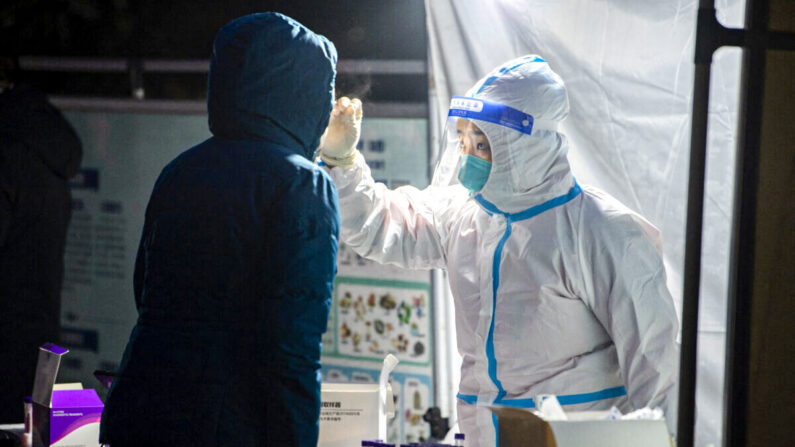 Un trabajador médico toma una muestra de hisopado a un residente para realizar la prueba de la COVID-19 en la ciudad de Xi'an, provincia de Shaanxi, China, el 25 de diciembre de 2021. (STR/AFP a través de Getty Images)