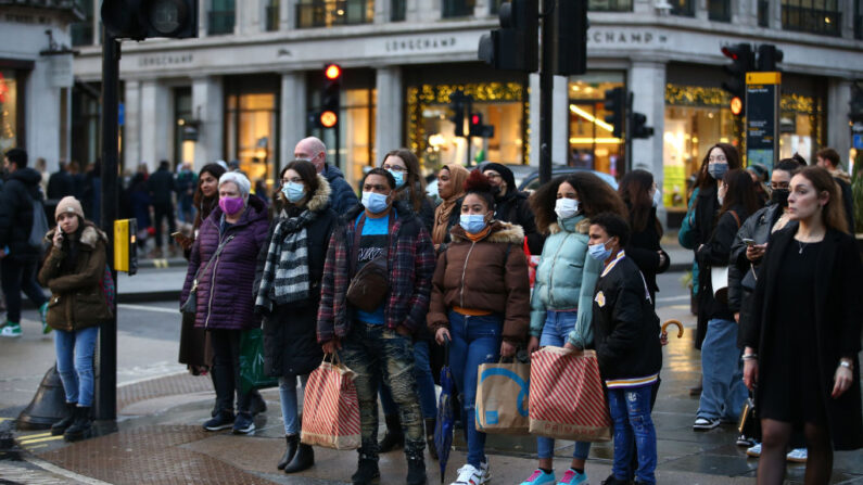 Los compradores esperan en los semáforos de la calle Regent Street el 27 de diciembre de 2021 en Londres, Inglaterra. (Hollie Adams/Getty Images)