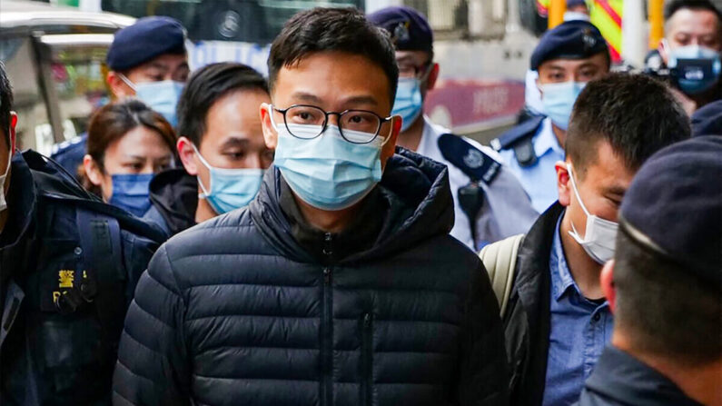 El editor jefe de Stand News, Patrick Lam, es llevado al edificio de oficinas del medio de comunicación esposado después de que la policía se desplegara para registrar las instalaciones en el distrito de Kwun Tong de Hong Kong el 29 de diciembre de 2021. (Daniel Suen/AFP vía Getty Images)