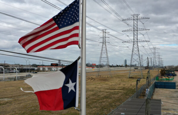 Las banderas de Estados Unidos y Texas ondean frente a torres de transmisión de alto voltaje, el 21 de febrero de 2021, en Houston, Texas. (Justin Sullivan/Getty Images)
