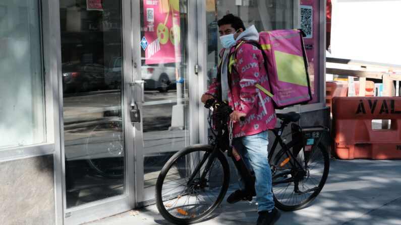 Un ciclista de reparto de Buyk se encuentra frente al centro de distribución de Buyk en Manhattan el 10 de noviembre de 2021 en la ciudad de Nueva York, Nueva York (EE.UU.). (Spencer Platt/Getty Images)