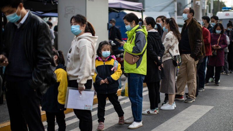 Los residentes llevan mascarillas mientras hacen fila para recibir las vacunas contra el COVID-19 en un centro de vacunación el 18 de noviembre de 2021 en Wuhan, China. (Getty Images)