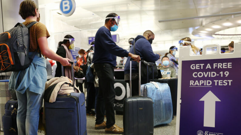 Las personas que llegaron en vuelos internacionales esperan para ser examinadas en el primer día de un nuevo sitio de pruebas rápidas de COVID-19 para los pasajeros internacionales que llegan al Aeropuerto Internacional de Los Ángeles (LAX) el 3 de diciembre de 2021 en Los Ángeles, California. (Mario Tama/Getty Images)