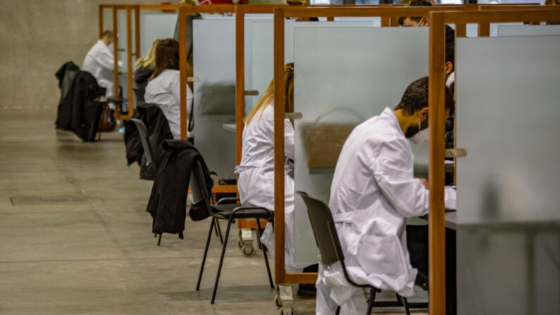 Médicos realizando una némesis a las personas antes de dejarles acceder a la vacunación, en la FieraMesse, centro ferial de Bolzano transformado en centro de vacunación contra el covid-19 en el Tirol del Sur, el 11 de diciembre de 2021 en Bolzano, Italia. (Francesca Volpi/Getty Images)