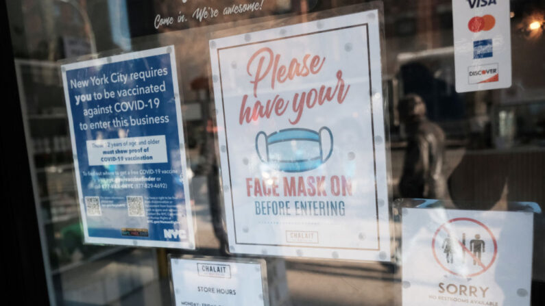Un cartel en la puerta de una cafetería en Manhattan pide una prueba de vacunación y el uso de una mascarilla el 13 de diciembre de 2021 en la ciudad de Nueva York. (Spencer Platt/Getty Images)