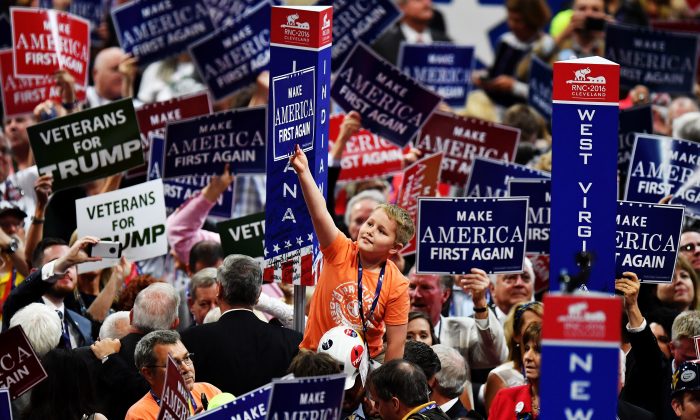 Varios delegados sostienen carteles en los que se puede leer "Make America First Again" durante la apertura del tercer día de la Convención Nacional Republicana el 20 de julio de 2016 en el Quicken Loans Arena en Cleveland, Ohio. (Jeff J Mitchell/Getty Images)