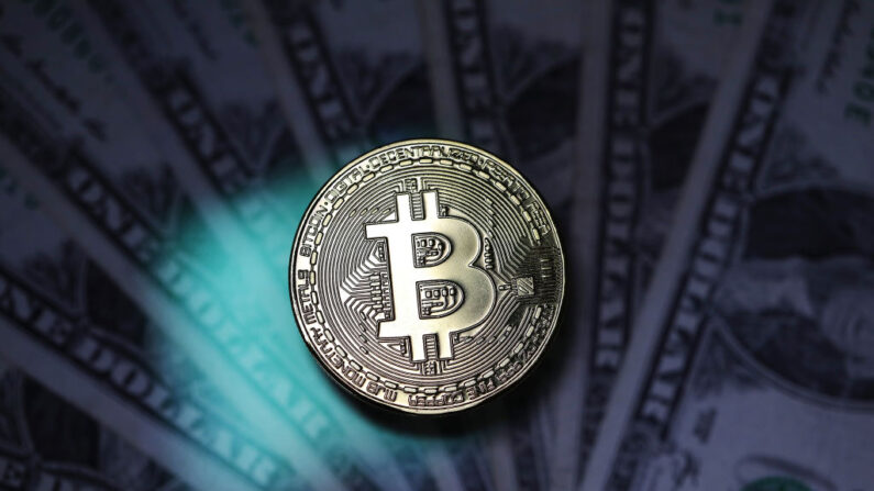 Una representación visual de la criptodivisa digital, Bitcoin junto a dólares estadounidenses el 07 de diciembre de 2017 en Londres, Inglaterra. (Dan Kitwood/Getty Images)